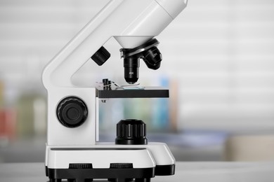 Photo of Modern medical microscope on table in laboratory, closeup. Space for text