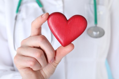Photo of Doctor with red decorative heart, closeup view