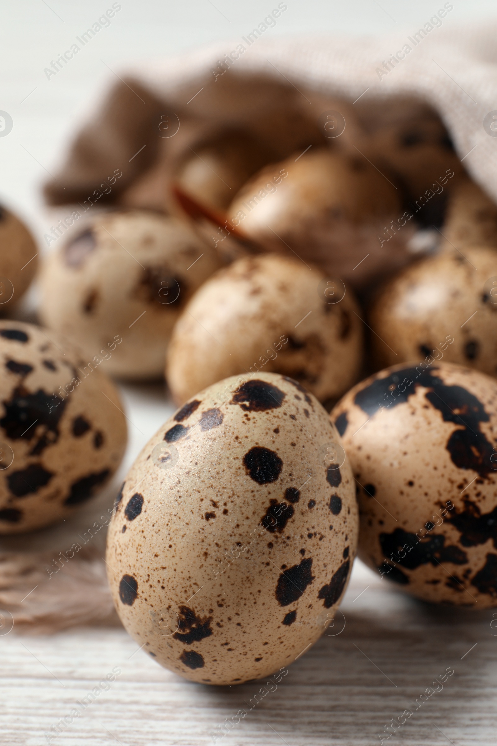 Photo of Fresh quail eggs on white wooden table, closeup