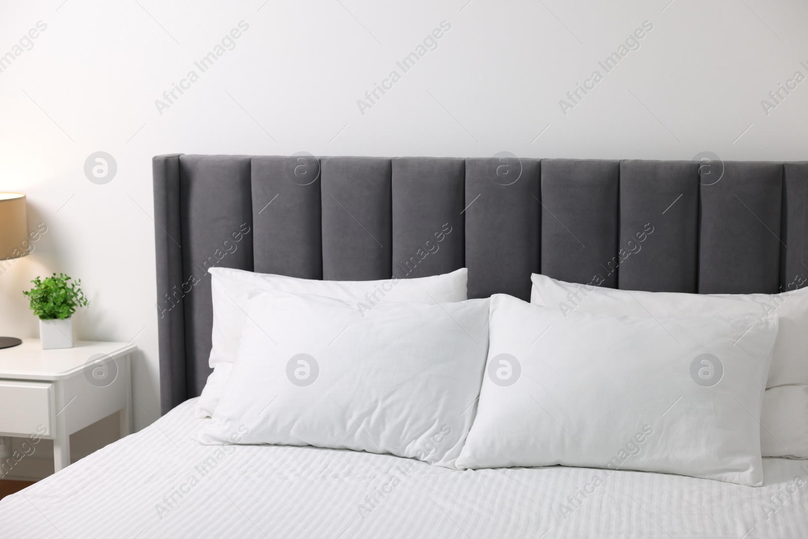 Photo of Soft white pillows and bedsheet on bed at home