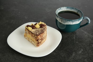 Photo of Piece of delicious Kyiv Cake served with coffee on black table