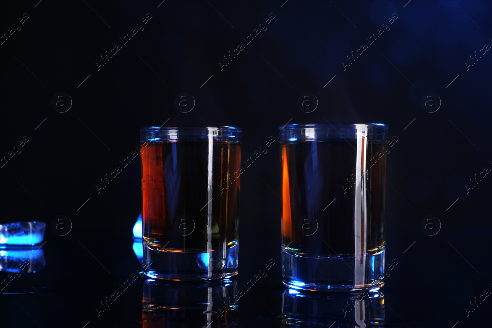 Photo of Alcohol drink in shot glasses on mirror surface