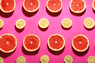 Photo of Flat lay composition with tasty ripe grapefruit slices on magenta background