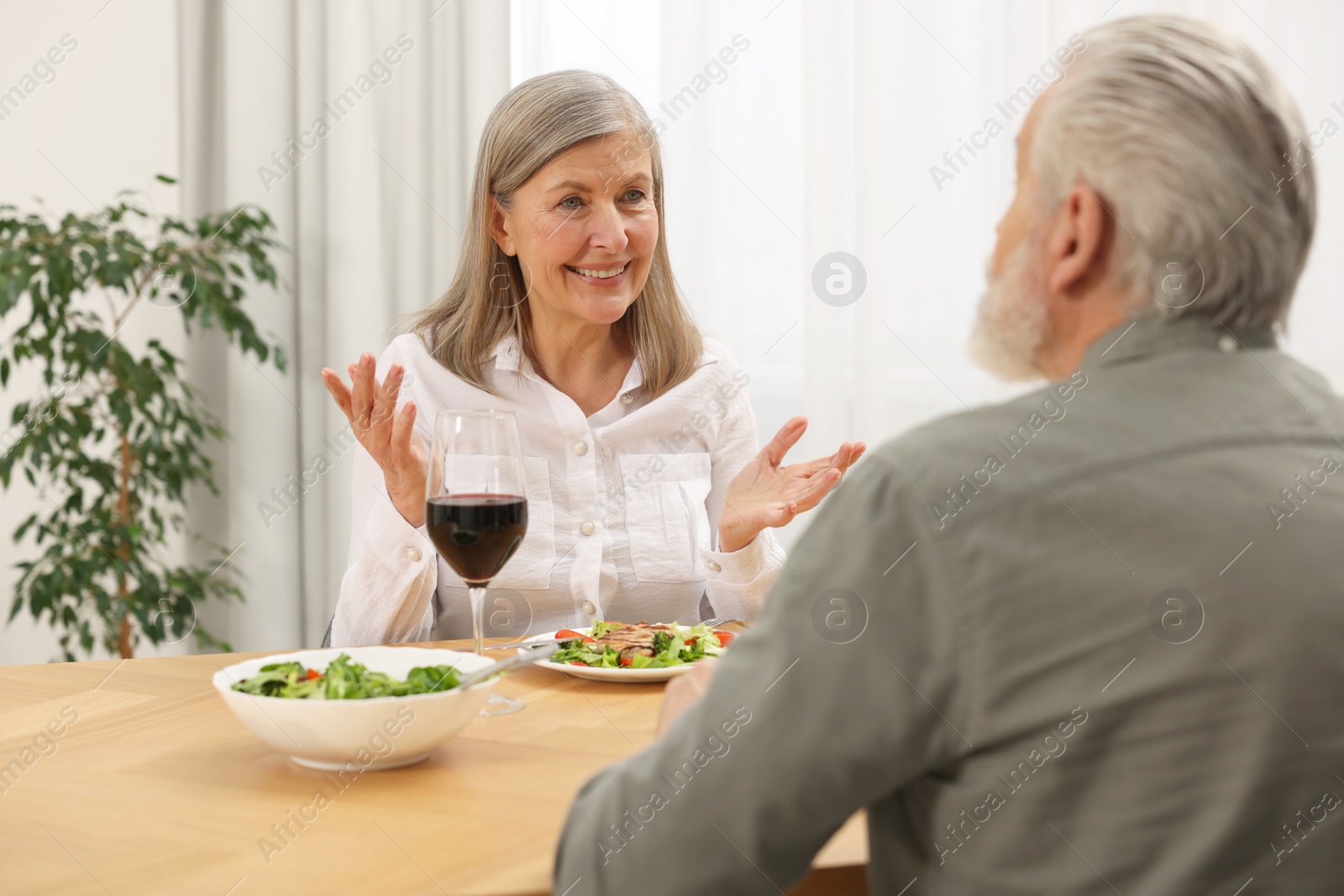 Photo of Happy senior couple having romantic dinner at home