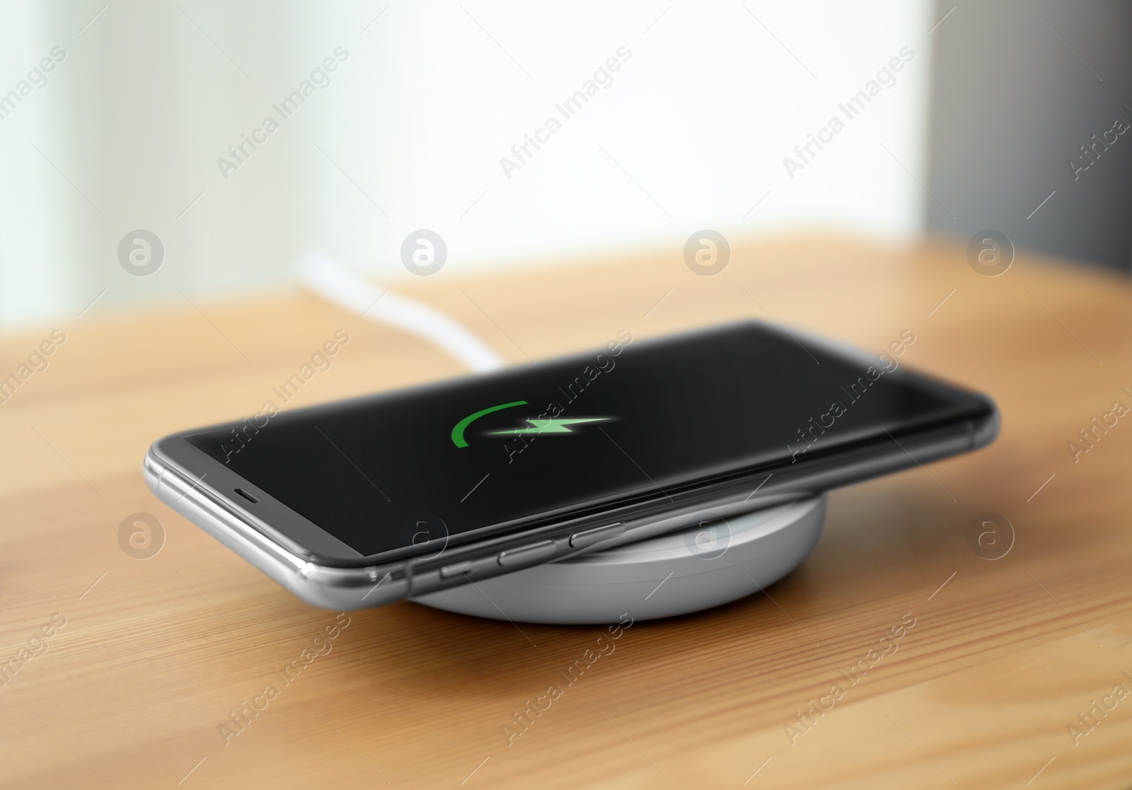 Photo of Smartphone charging on wireless pad in room