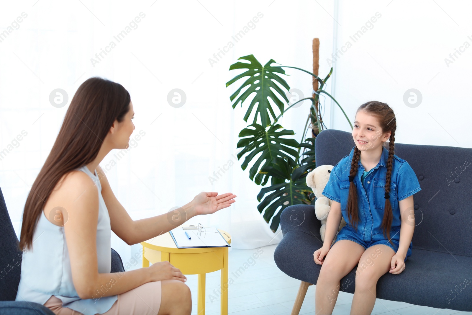 Photo of Child psychologist working with little girl in office