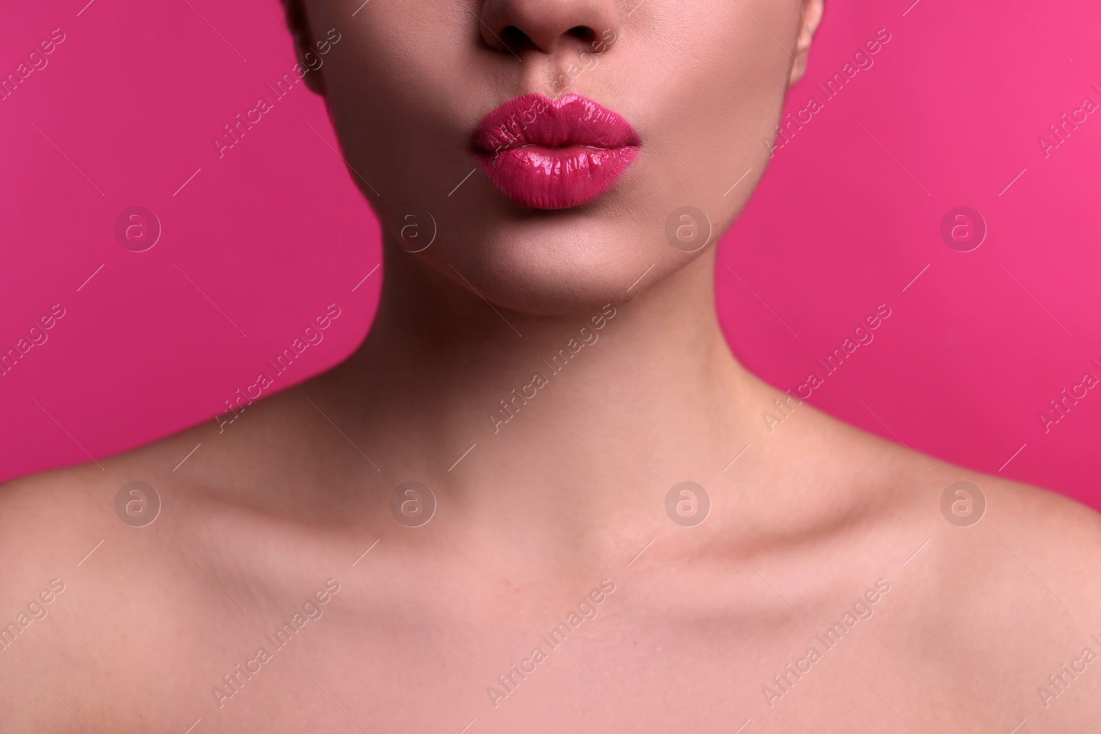 Photo of Closeup view of beautiful woman puckering lips for kiss on pink background