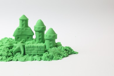 Castle figures and starfish made of green kinetic sand isolated on white