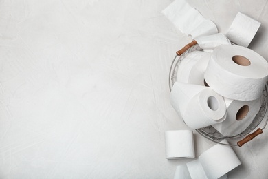 Photo of Basket with toilet paper rolls on grey background, top view. Space for text