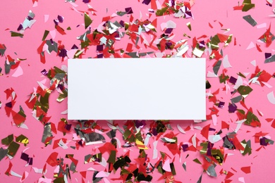 Photo of Blank card and shiny colorful confetti on pink background, flat lay. Space for text