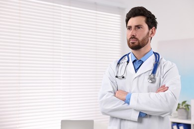 Medical consultant with stethoscope in clinic, space for text