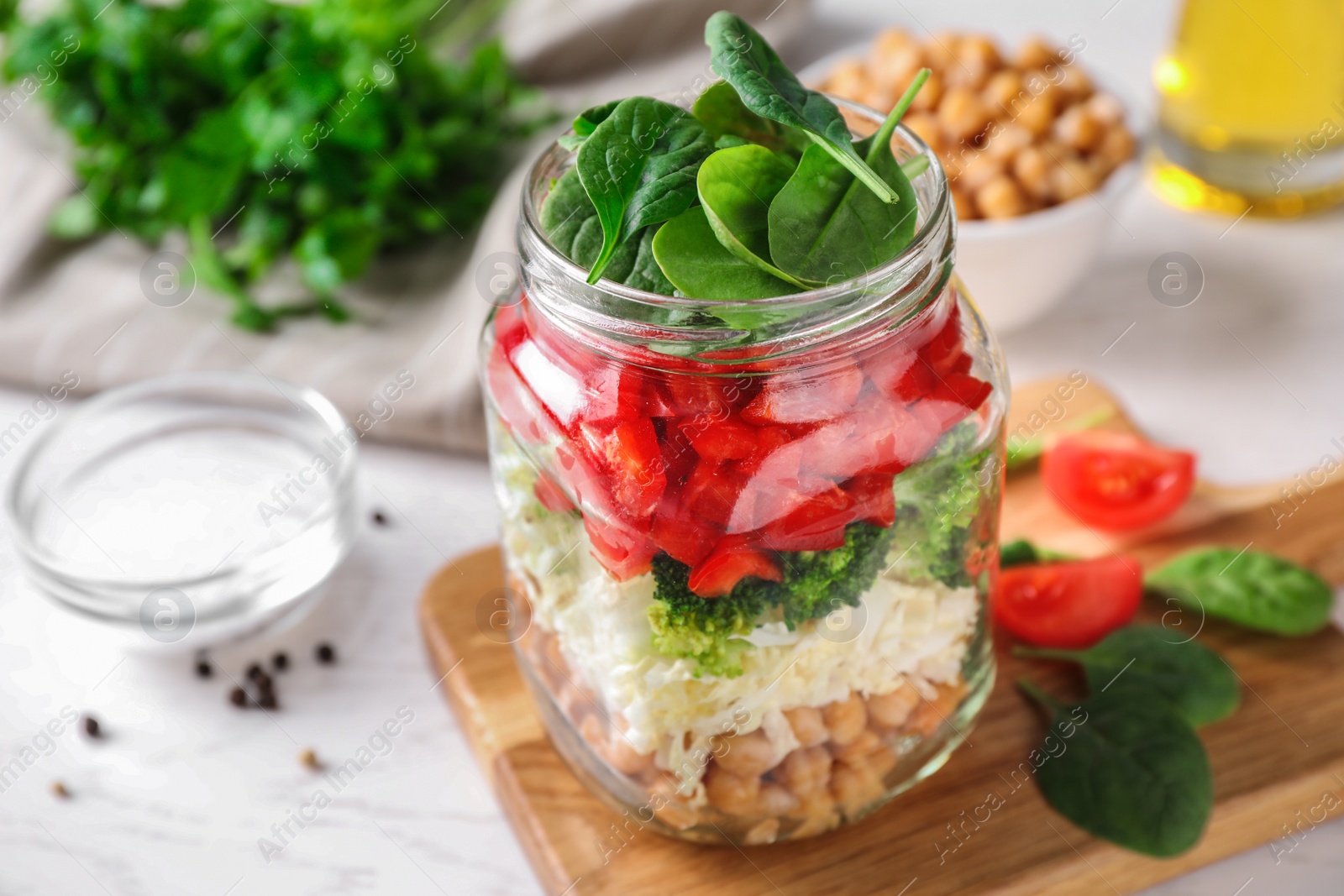 Photo of Healthy salad in glass jar on white table