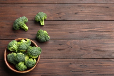 Photo of Flat lay composition of fresh green broccoli on wooden table, space for text