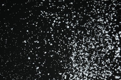 Photo of White snow falling down on black background