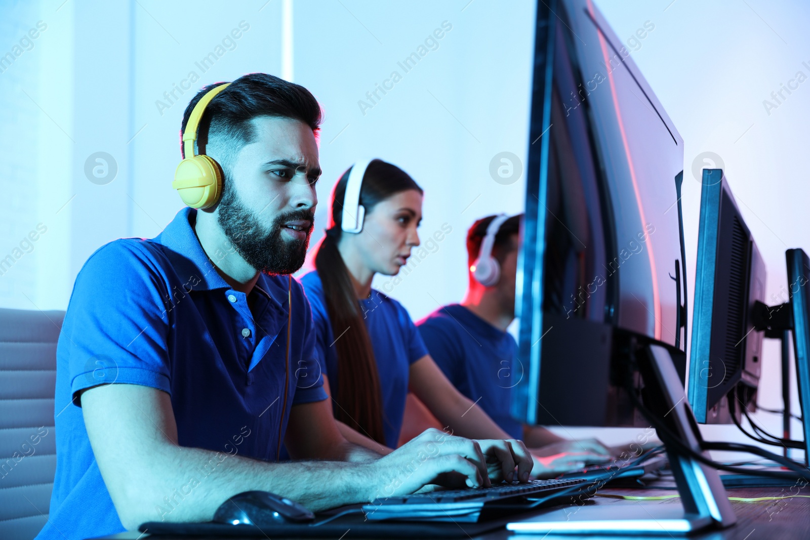 Photo of Young people playing video games on computers indoors. Esports tournament