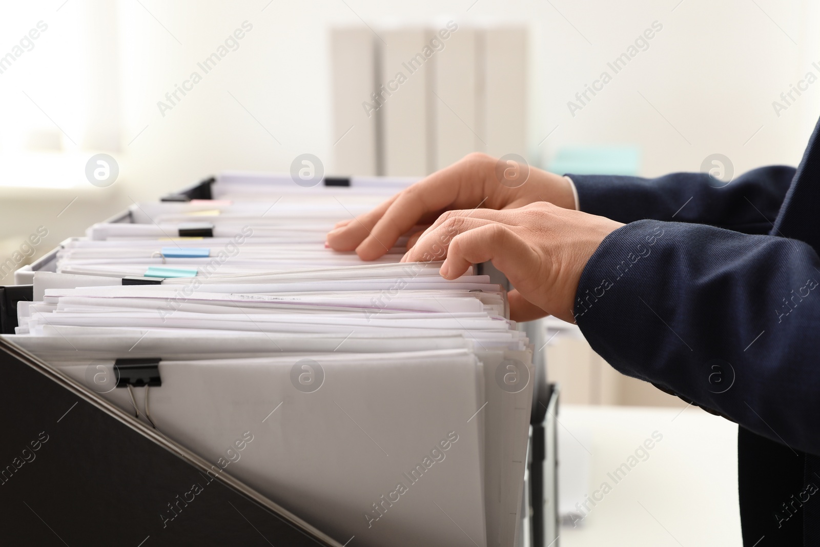 Photo of Woman taking documents from folder in archive, closeup