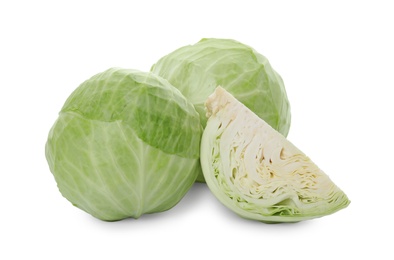 Whole and cut fresh ripe cabbages on white background