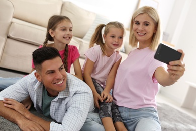 Happy family taking selfie on floor at home