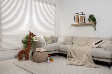 Photo of Stylish child room with comfortable sofa and toys. Interior design