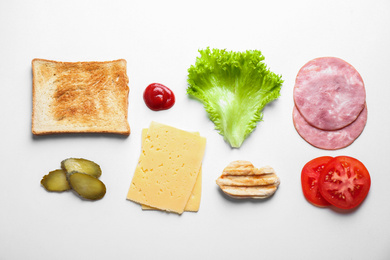 Fresh ingredients for tasty sandwich on white background, top view