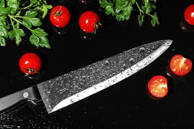 Photo of Chef's knife and products on black background