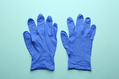 Pair of medical gloves on light blue background, flat lay