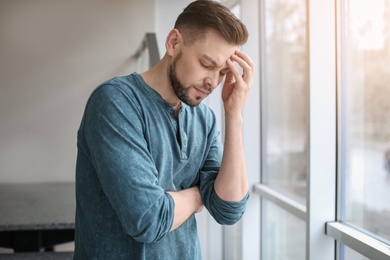 Photo of Man suffering from headache at home