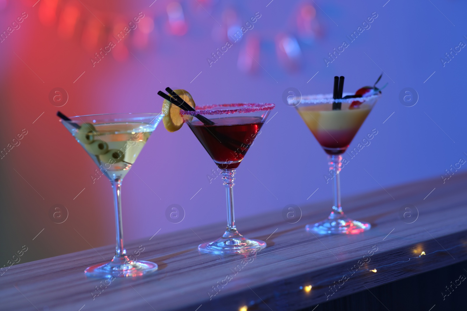 Photo of Different martini cocktails on table in bar