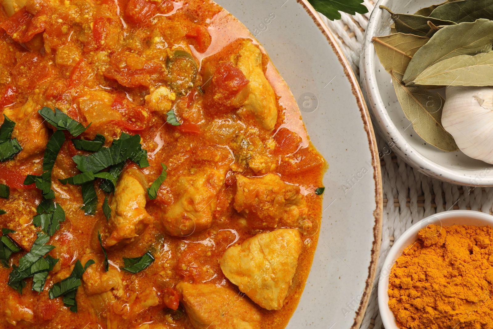 Photo of Delicious chicken curry and spices on table, top view