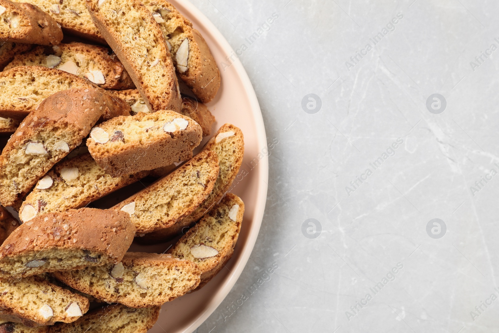 Photo of Traditional Italian almond biscuits (Cantucci) on light marble table, top view. Space for text