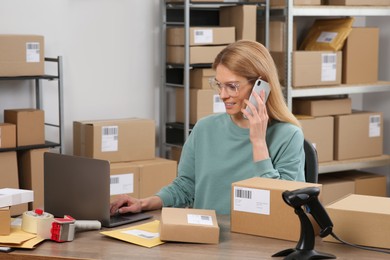 Seller talking on phone while working in office. Online store