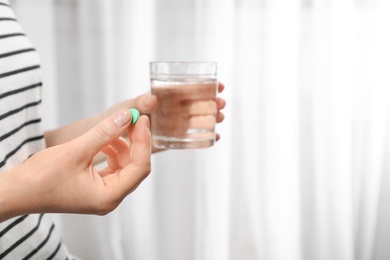 Photo of Young woman taking pill, closeup