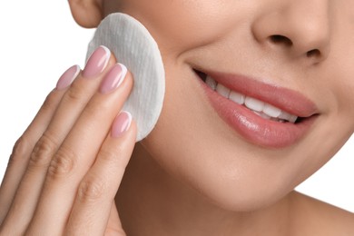 Beautiful woman removing makeup with cotton pad on white background, closeup