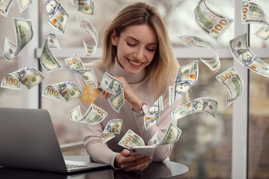 Image of Online payment. Woman with credit card buying something using mobile phone at home. Dollar banknotes flying out of gadget as process of money transaction
