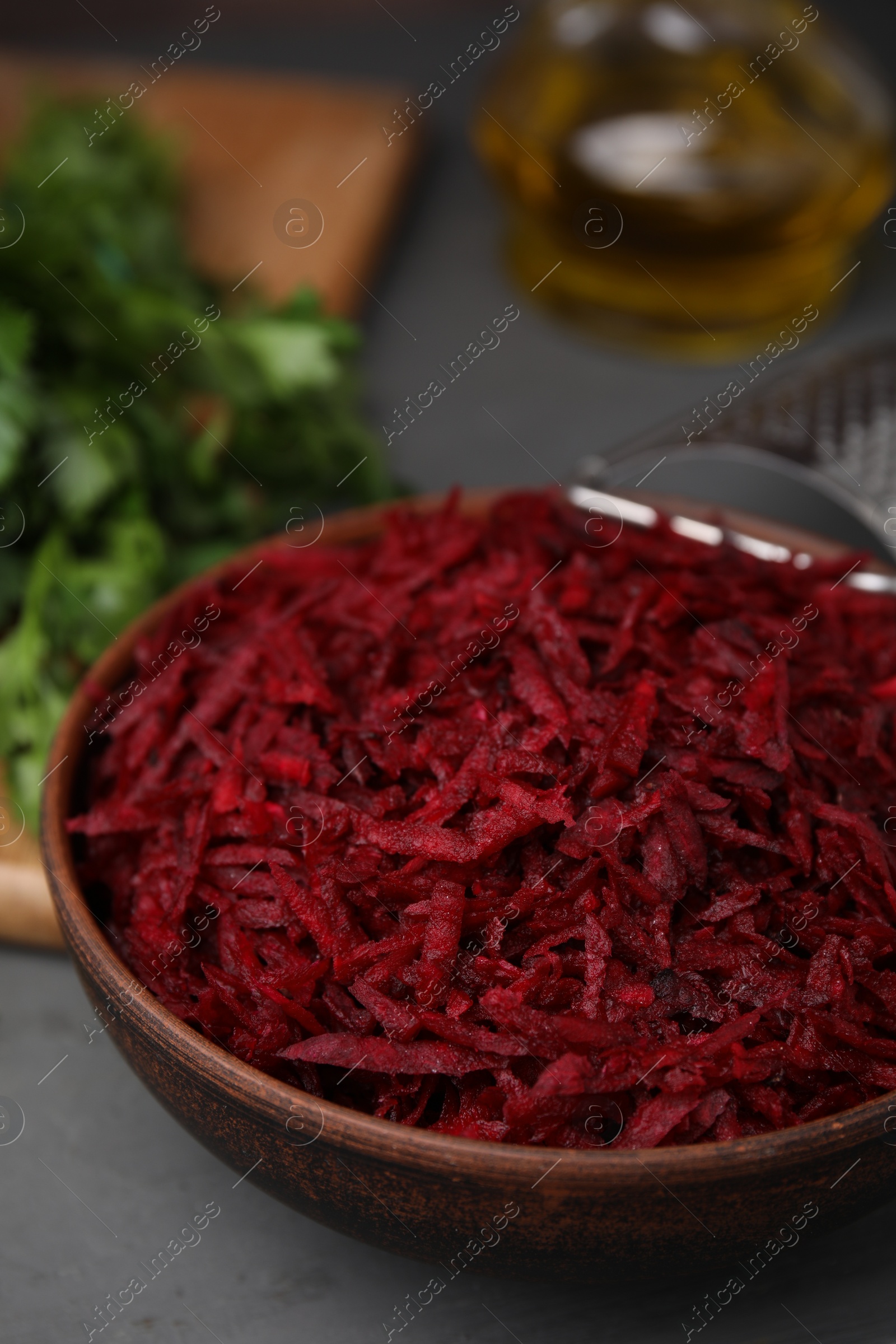 Photo of Grated red beet in bowl on table, closeup