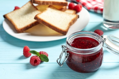 Image of Sweet raspberry jam and toasts for breakfast on turquoise wooden table