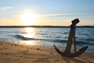 Wooden anchor near river on sunny day