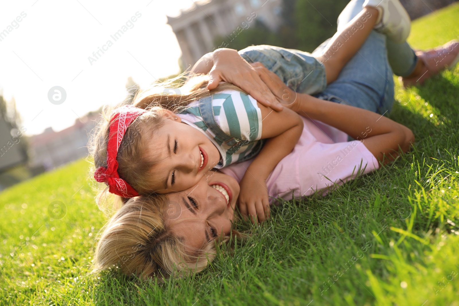 Photo of Happy mother and her child having fun on green grass. Spending time in nature