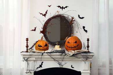 Photo of Different Halloween decor on mantelpiece indoors. Festive interior