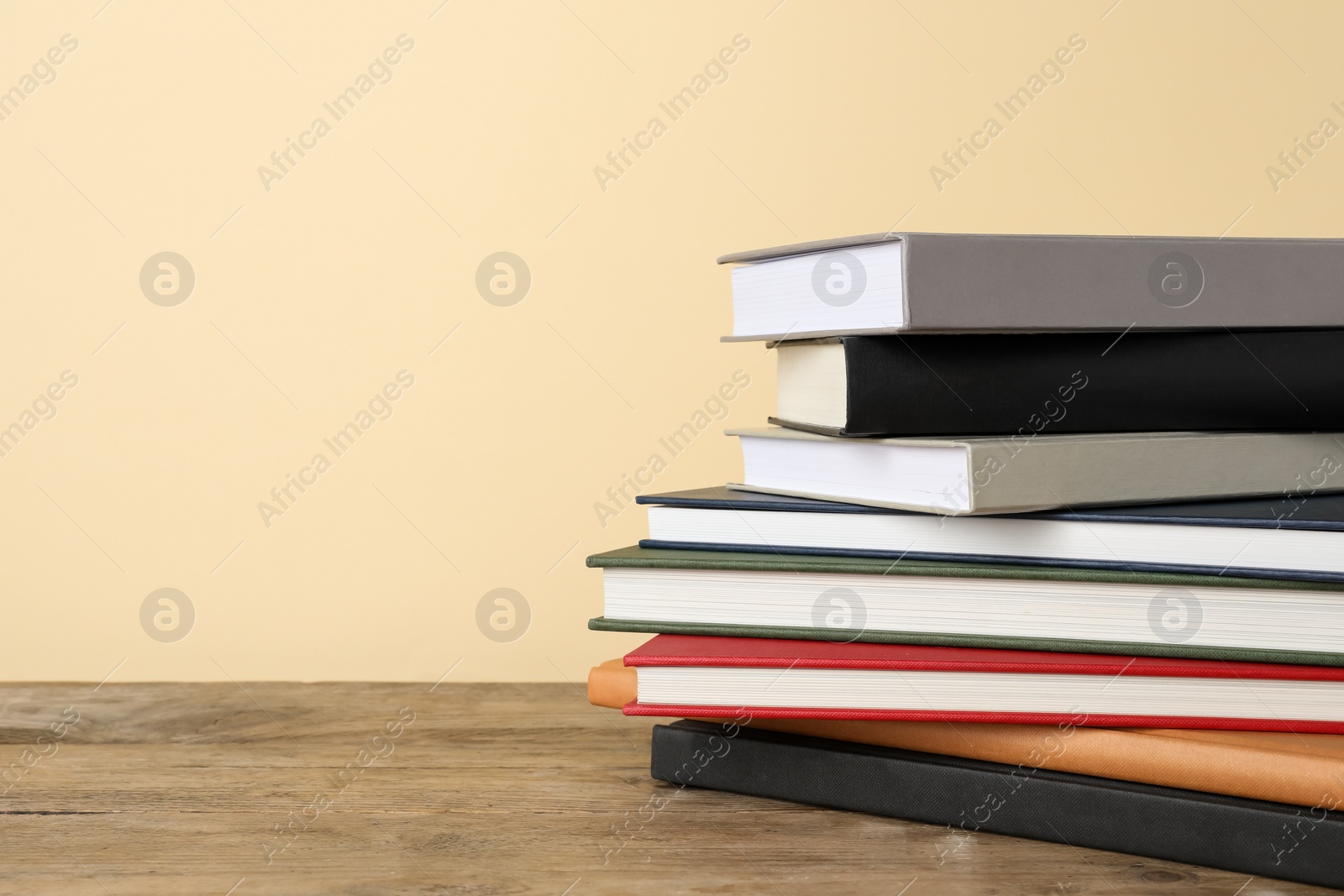 Photo of Stack of hardcover books on wooden table, space for text