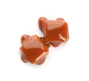 Delicious candies with caramel sauce on white background, top view