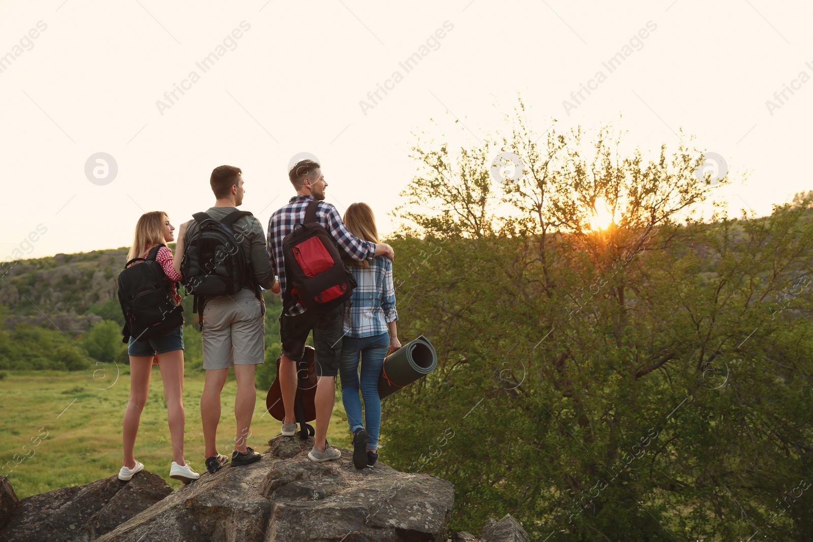 Photo of Group of young people with backpacks in wilderness. Camping season