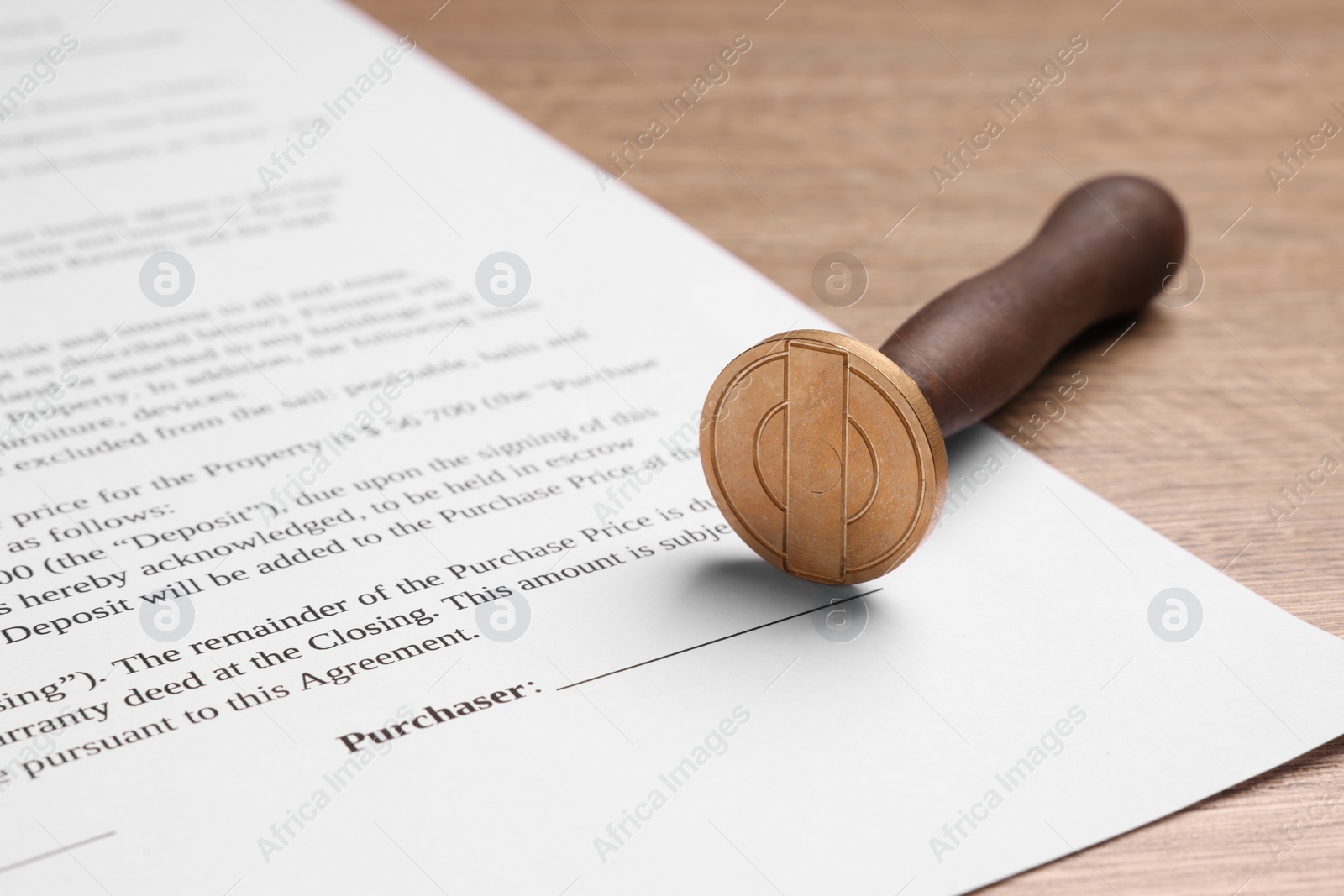 Photo of One stamp tool and document on wooden table, closeup