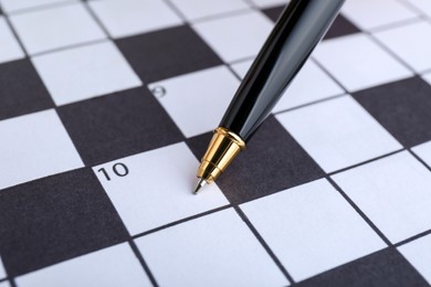 Photo of Pen on blank crossword, closeup. Intellectual entertainment