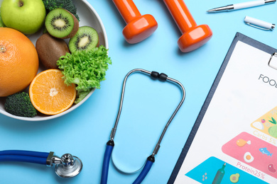 Photo of Fruits, vegetables, dumbbells, stethoscope and list of products on light blue background, flat lay. Visiting nutritionist