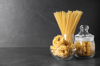Photo of Different types of pasta on black table, space for text