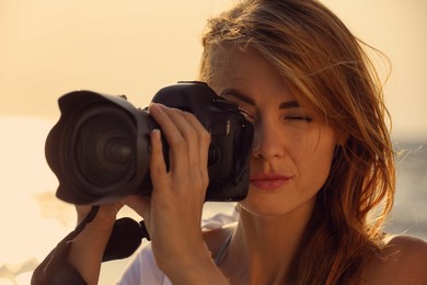 Photographer taking photo with professional camera outdoors, closeup