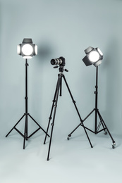 Photo of Professional video camera and lighting equipment on grey background