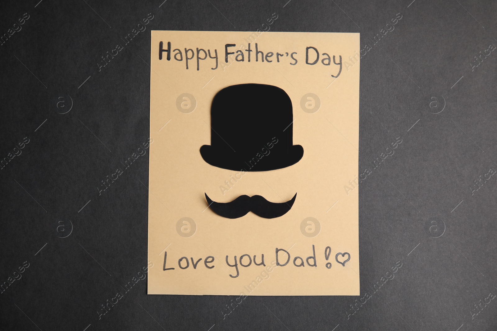 Photo of Greeting card with phrase HAPPY FATHER'S DAY I LOVE YOU DAD on black background, top view
