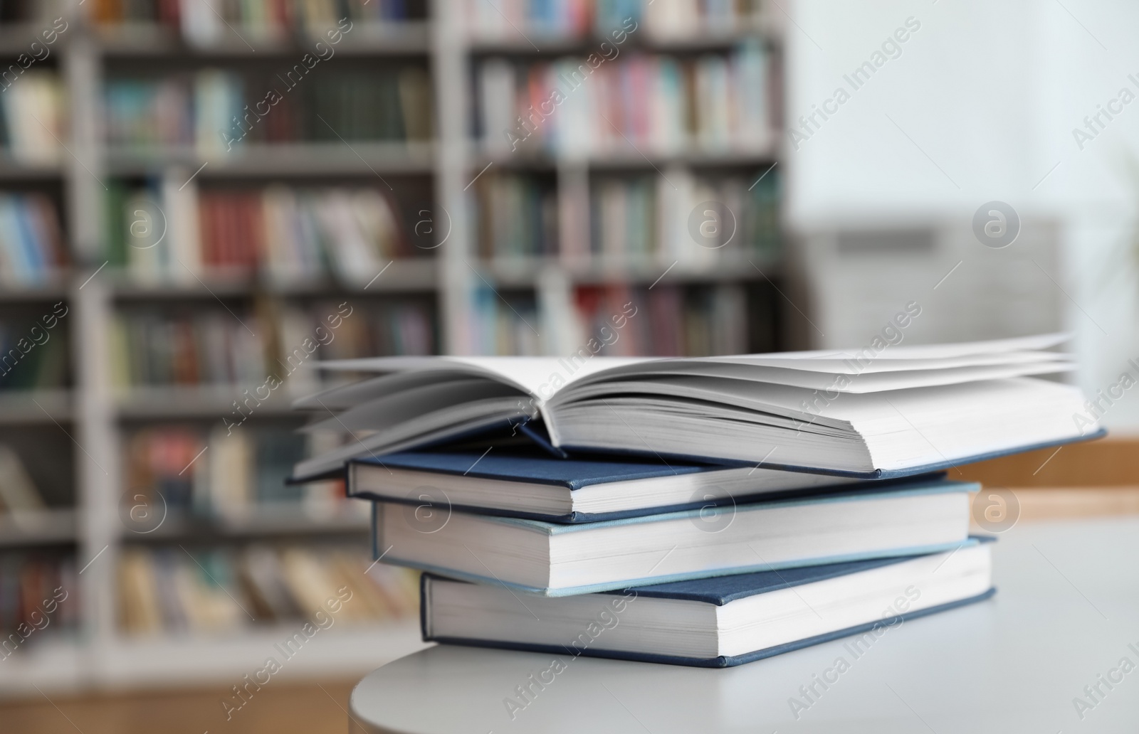 Photo of Stack of books on white table in library